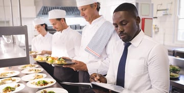 man holding book inspecting kitchen
