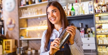 Female bartender holding a boston shaker. 