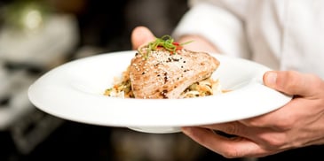 Food server holding a plate with tuna 