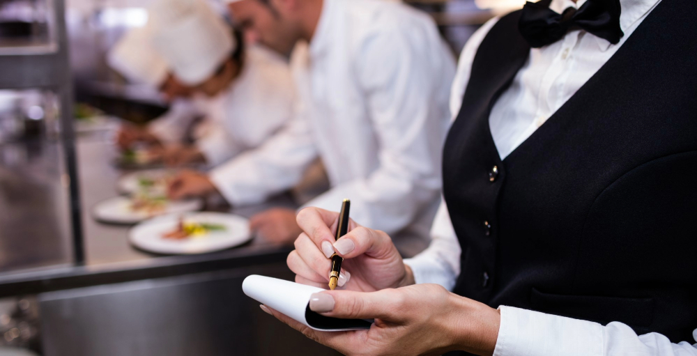 Server taking notes in kitchen