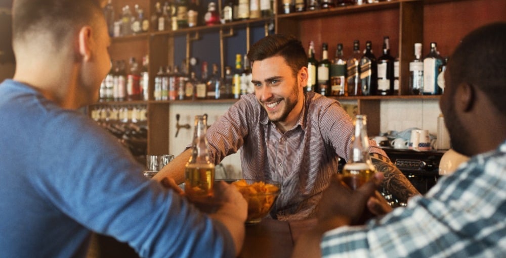 Smiling bartender with customers.
