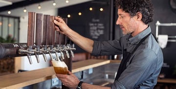 man pouring beer on tap